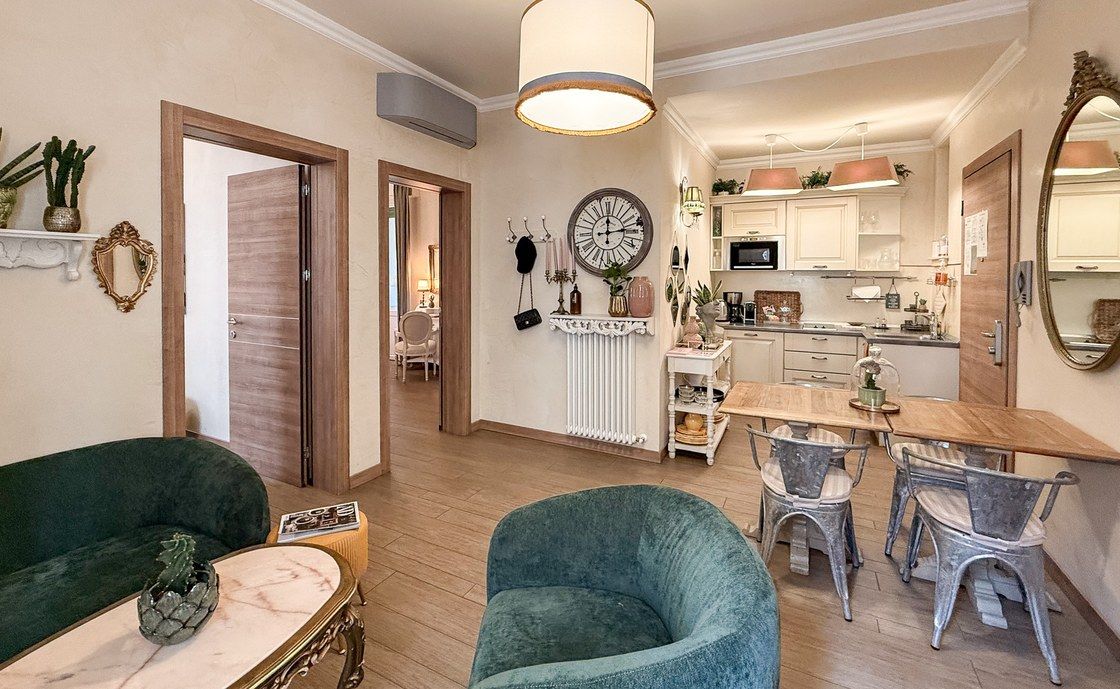 Essbereich in Madonna del Terraglio mit grünen Samtsesseln und Metallstühlen rund um den Tisch
