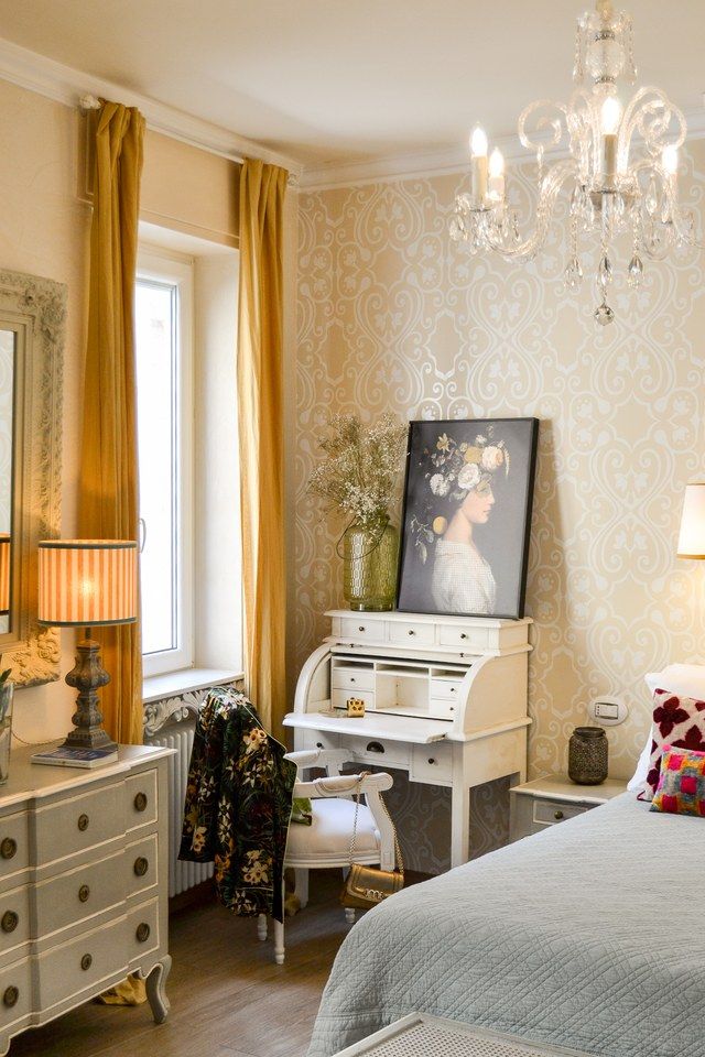 Schreibecke in einem Schlafzimmer von Madonna del Terraglio, mit weissem Sekretär und einem floralen Porträt